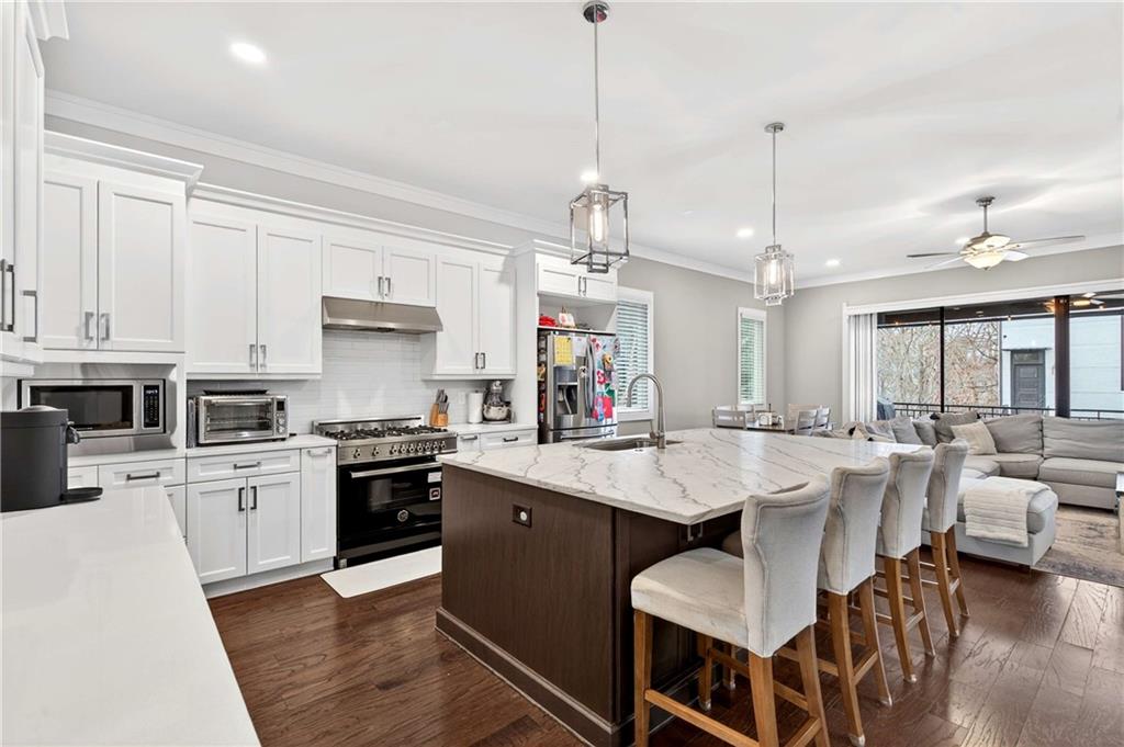 2974 Hermance Drive Northeast Atlanta, GA 30319 - Photo 8 of 38 a large kitchen with kitchen island white cabinets and stainless steel appliances