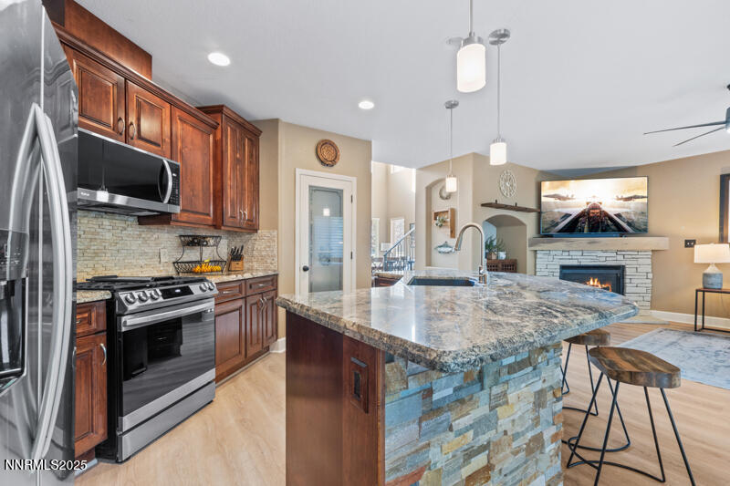 2968 Fox Trail Drive Reno, NV 89523 - Photo 7 of 24 a kitchen with stainless steel appliances granite countertop a stove top oven a sink dishwasher a dining table and chairs with wooden floor