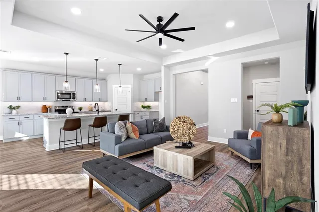 a living room with lots of furniture and kitchen view