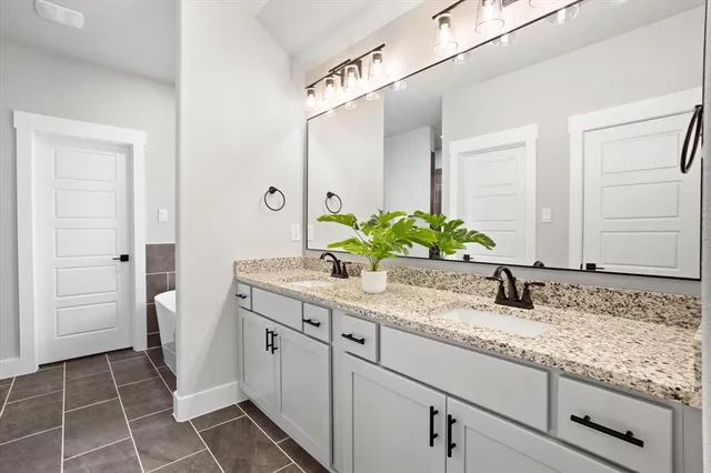 a bathroom with a granite countertop sink and a mirror