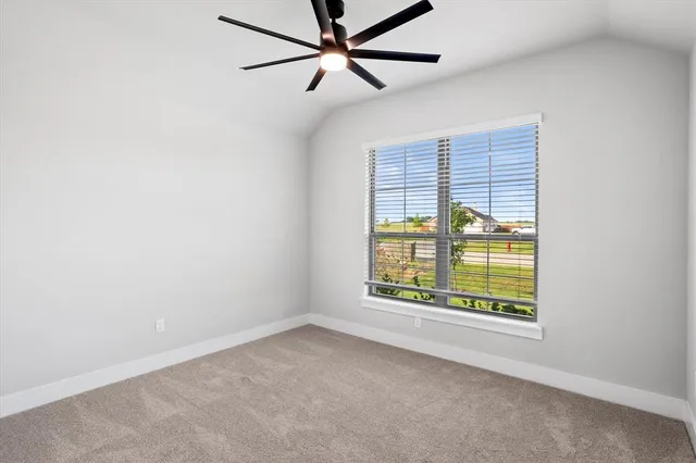 an empty room with a window and a ceiling fan