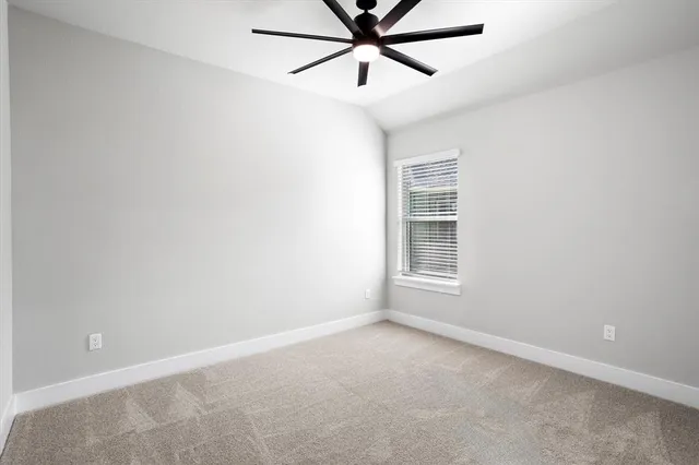a view of a room with a ceiling fan and a window