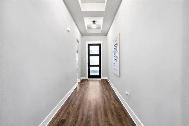 a view of a hallway with wooden floor and windows