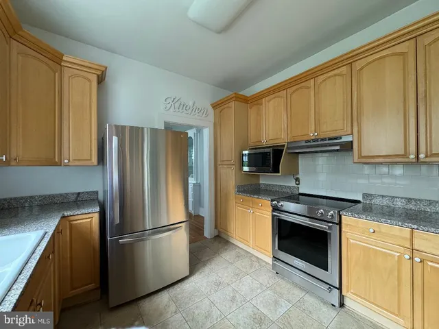 a kitchen with stainless steel appliances granite countertop a refrigerator stove and sink