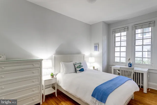 a bedroom with a bed and a window with balcony view