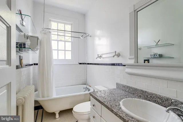 a bathroom with a granite countertop sink mirror toilet and bathtub