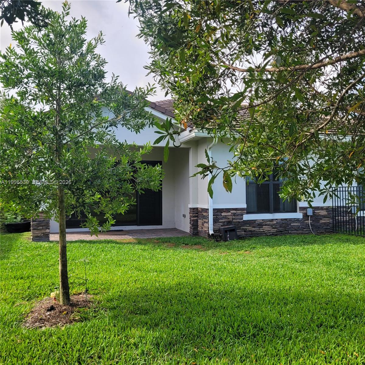 a view of a house with a yard and sitting area