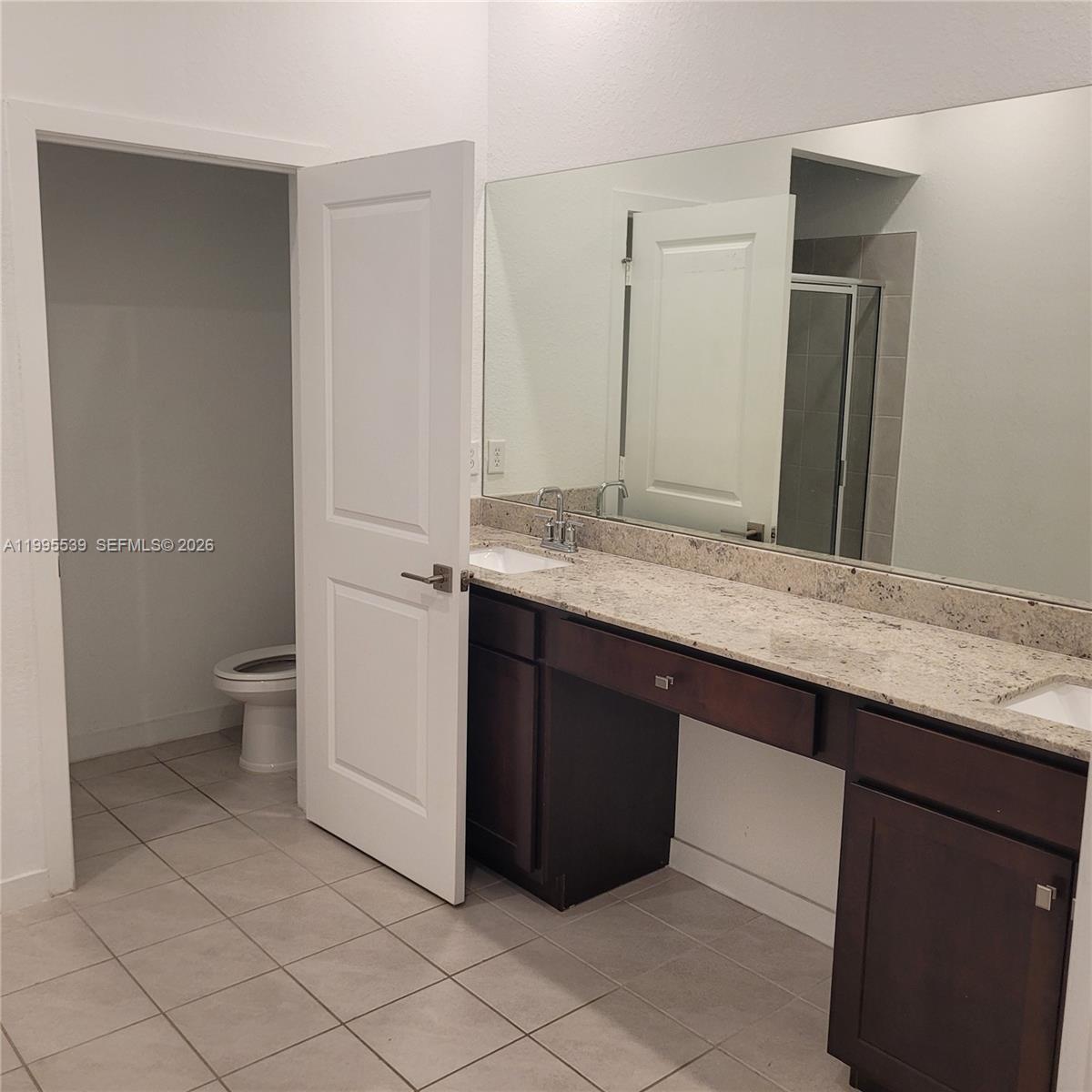 19723 Weathervane Way Loxahatchee, FL 33470 - Photo 20 of 24 a bathroom with a granite countertop sink a toilet and a mirror