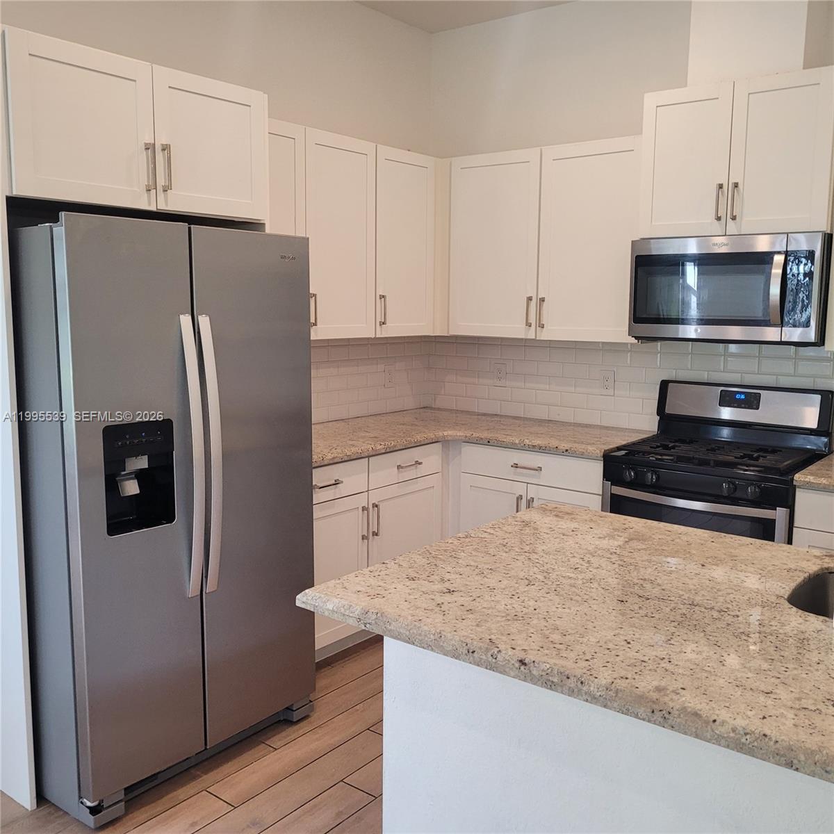 19723 Weathervane Way Loxahatchee, FL 33470 - Photo 6 of 24 a kitchen with stainless steel appliances granite countertop a refrigerator a stove and a sink
