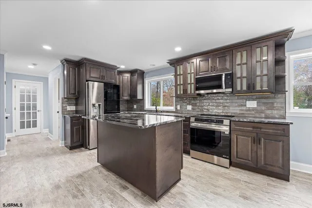 an empty room with kitchen and natural light