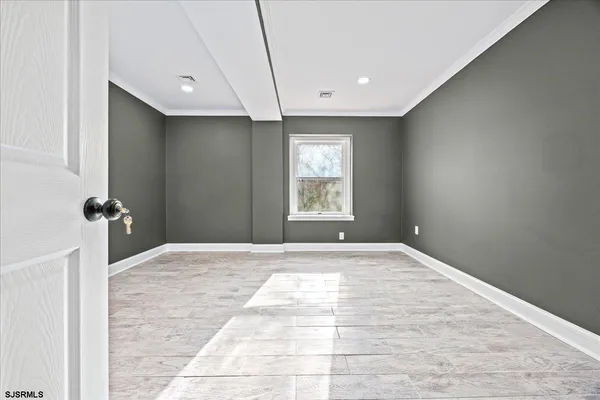 a view of a livingroom with wooden floor and kitchen