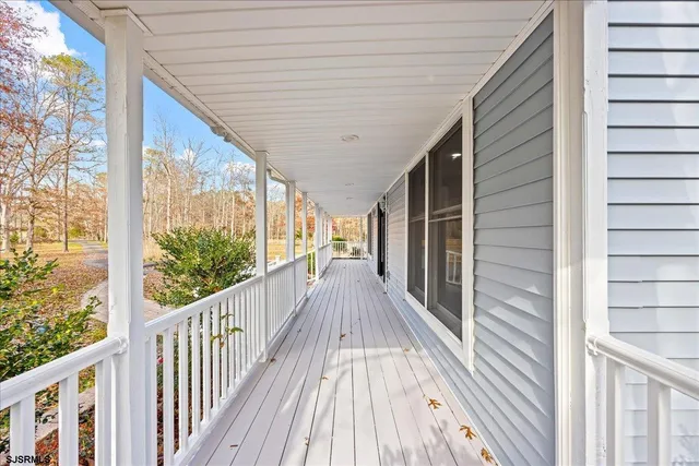 a view of a livingroom with wooden floor and kitchen