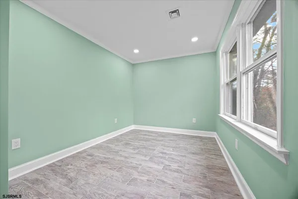 a view of empty room with wooden floor