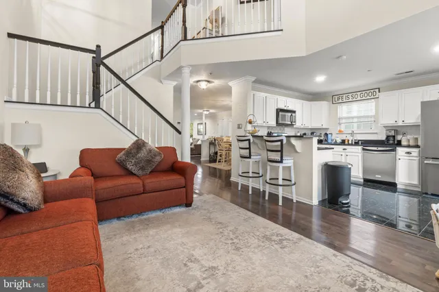 a living room with stainless steel appliances kitchen island granite countertop a couch and a view of living room