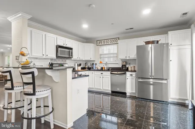 a kitchen with stainless steel appliances granite countertop a refrigerator sink and cabinets