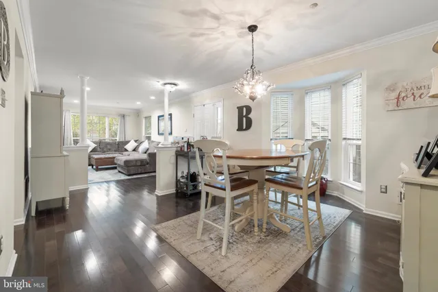 a view of a dining room and livingroom with furniture wooden floor a chandelier