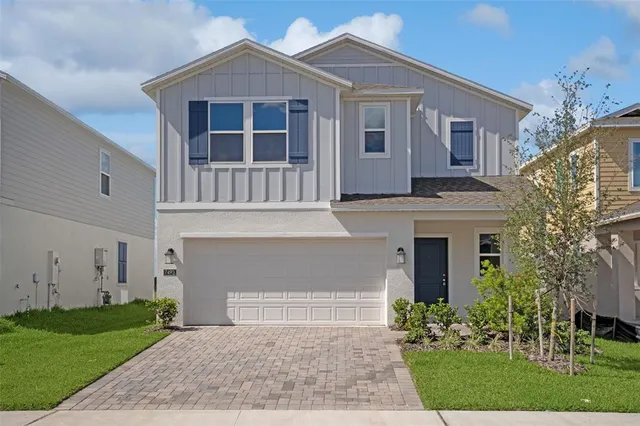a front view of a house with a garden and yard