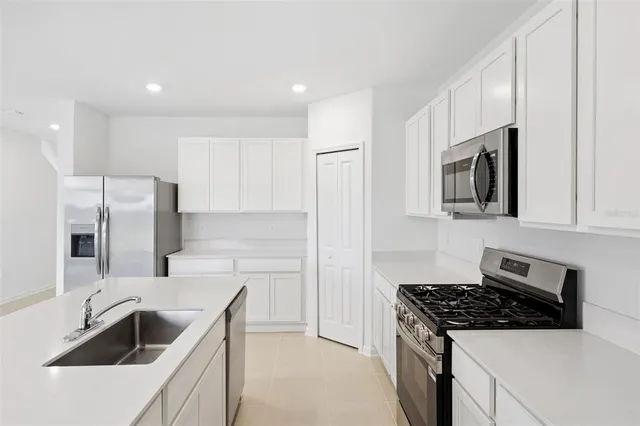 a kitchen that has a sink and a stove top oven