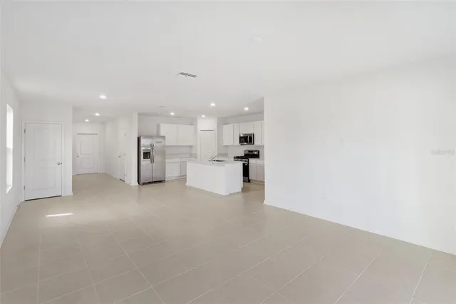 a view of an empty room with kitchen