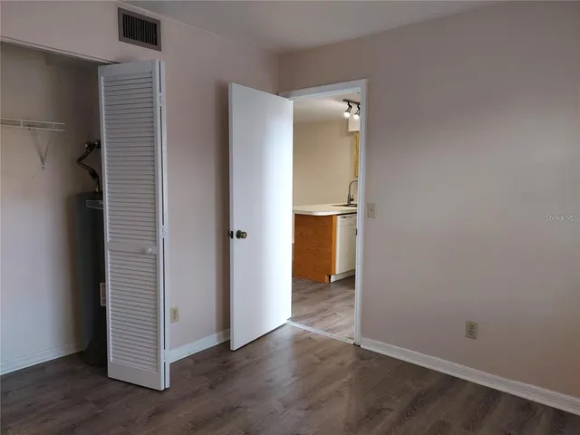 an empty room with wooden floor and closet