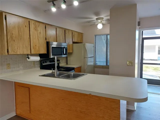 a kitchen with stainless steel appliances granite countertop a sink a stove and a refrigerator