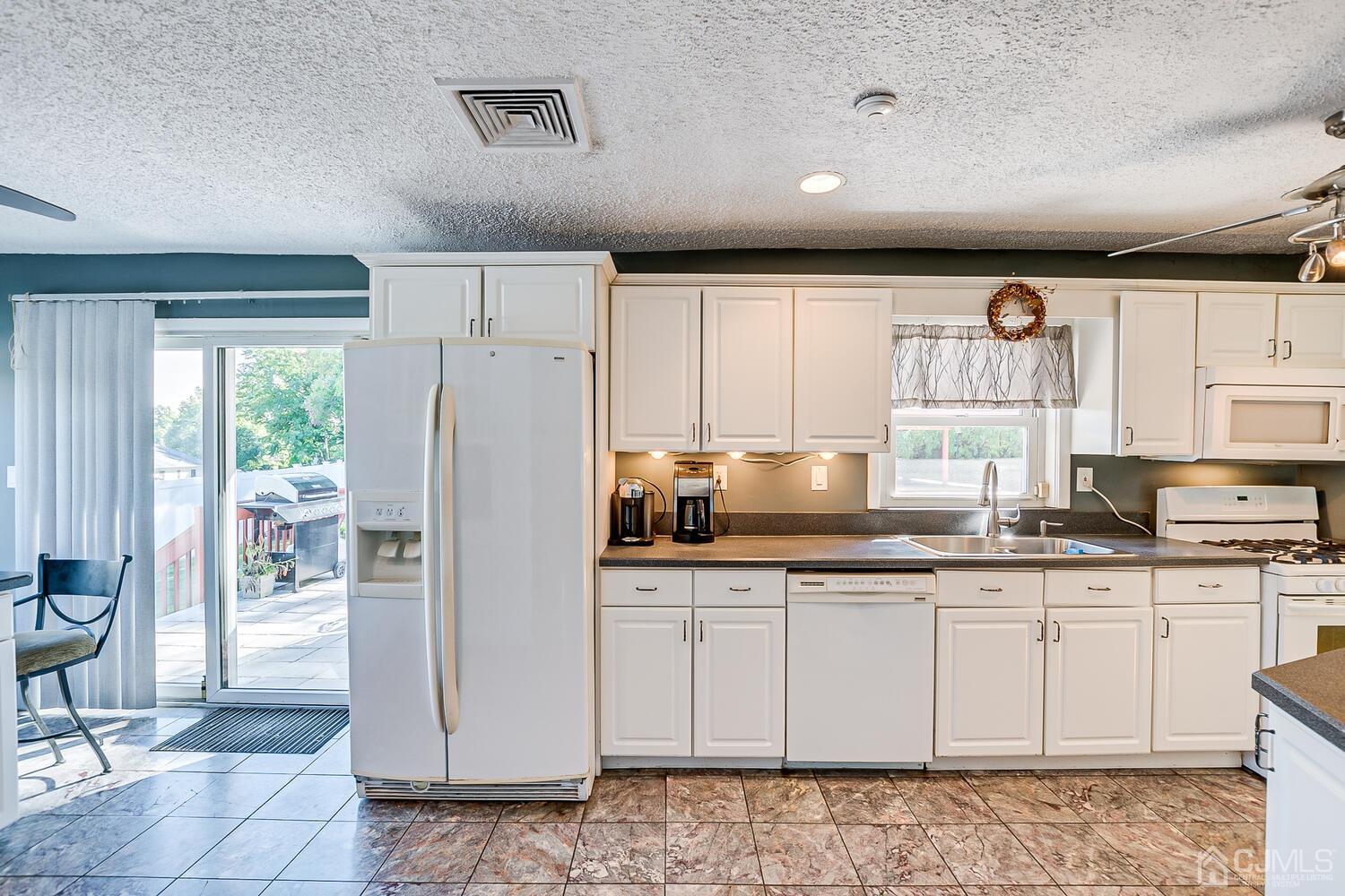 3 Normandy Road Colonia, NJ 07067 - Photo 11 of 40 a kitchen with granite countertop white cabinets and white appliances