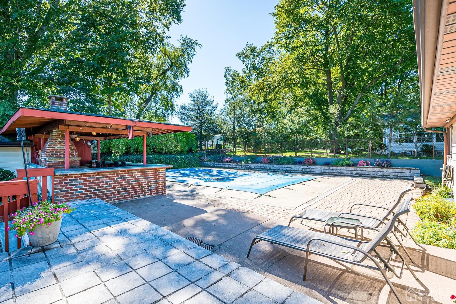 3 Normandy Road Colonia, NJ 07067 - Photo 30 of 40 a view of swimming pool with seating space and trees in the background