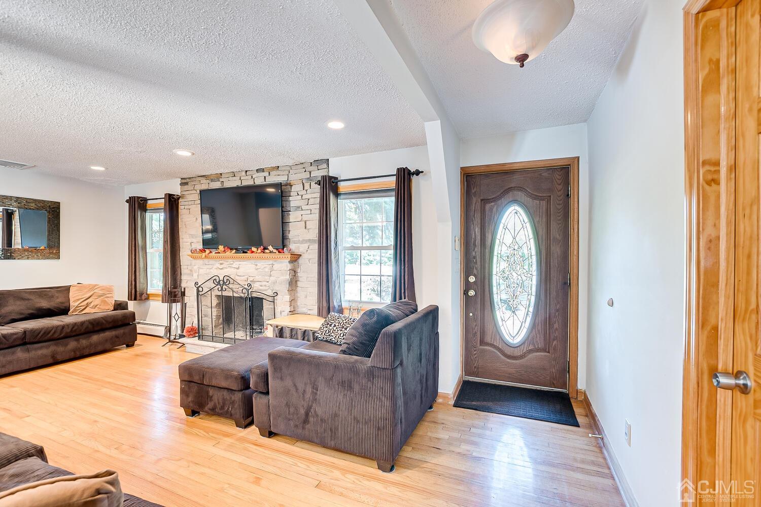 3 Normandy Road Colonia, NJ 07067 - Photo 5 of 40 a living room with furniture a fireplace and a large window