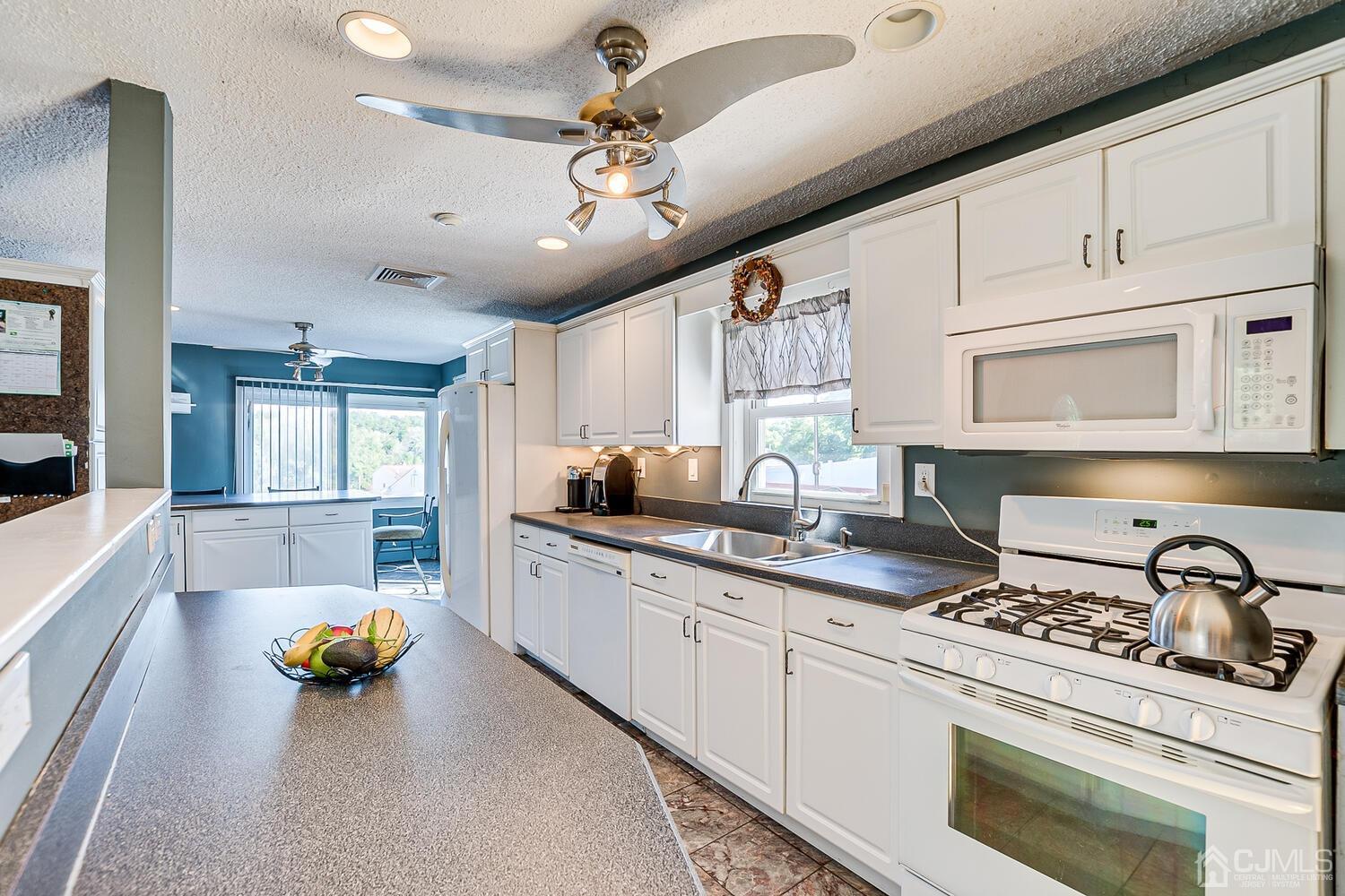 3 Normandy Road Colonia, NJ 07067 - Photo 10 of 40 a kitchen with stainless steel appliances a stove a sink cabinets and a window