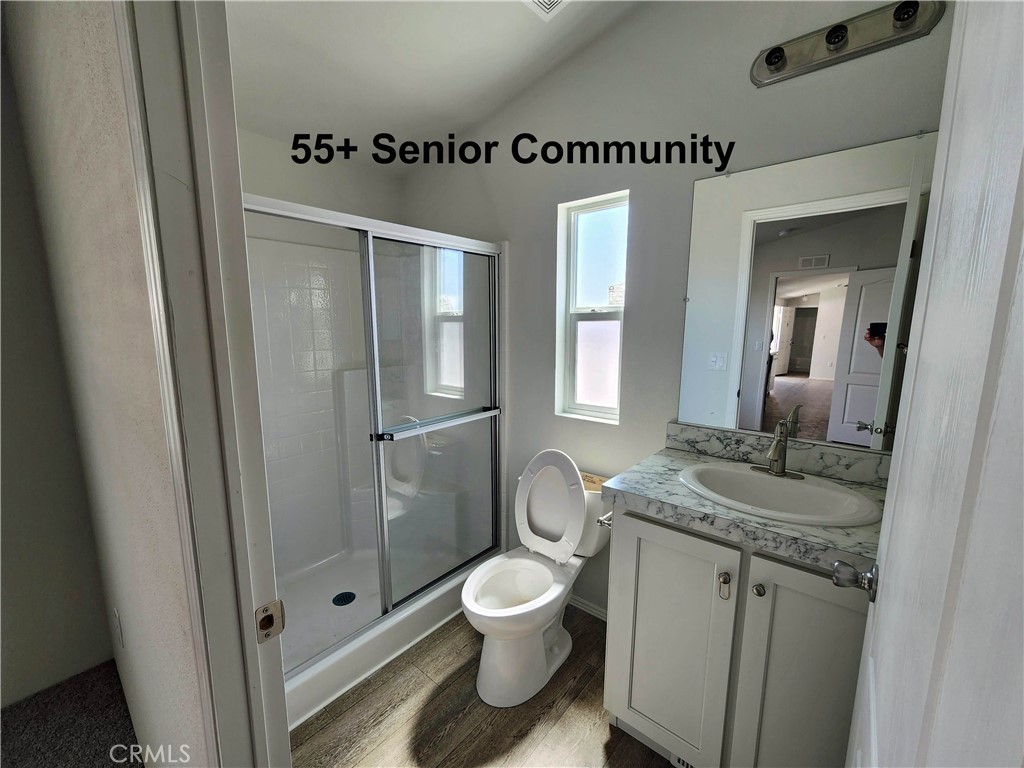 43601 East Florida Avenue, Unit 1A Hemet, CA 92544 - Photo 12 of 16 a bathroom with a granite countertop toilet a sink and a mirror