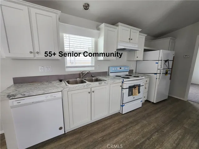 a kitchen with granite countertop white cabinets and white appliances