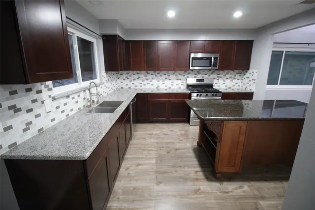 a kitchen with a sink and a stove top oven