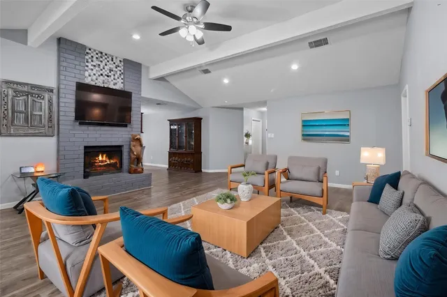 a living room with furniture a flat screen tv and a fireplace