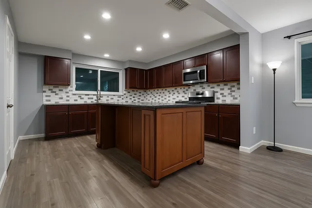 an empty room with wooden floor and a ceiling fan
