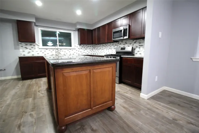 a front view of a house with a yard and large tree