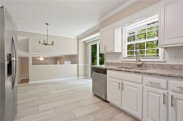 a kitchen with granite countertop a sink cabinets and window