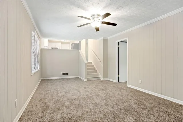 an empty room with ceiling fan and window