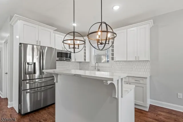 a kitchen with stainless steel appliances a sink a stove a refrigerator and cabinets