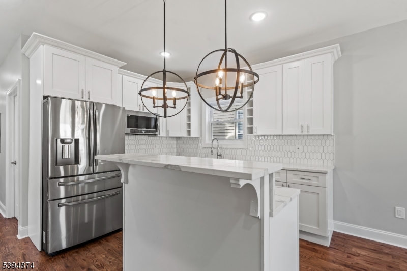 a kitchen with stainless steel appliances a sink a stove a refrigerator and cabinets