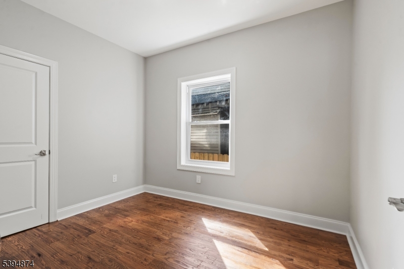 53 Marcy Avenue, Unit 1 East Orange, NJ 07017 - Photo 11 of 23 a view of an empty room with wooden floor and a window