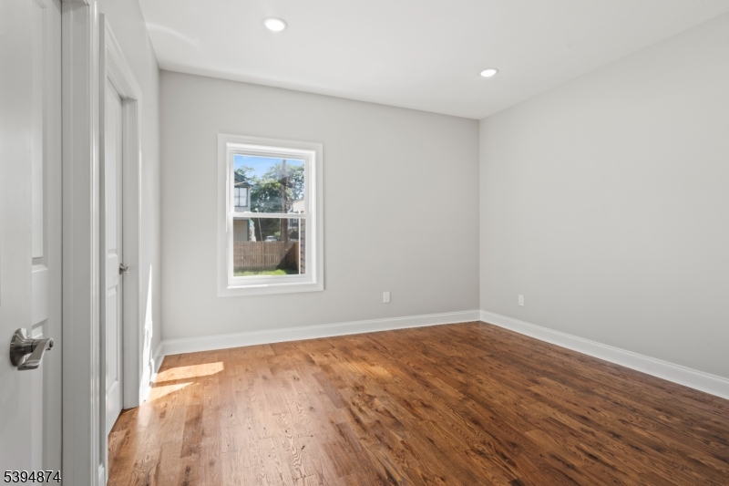 53 Marcy Avenue, Unit 1 East Orange, NJ 07017 - Photo 13 of 23 a view of an empty room with wooden floor and a window