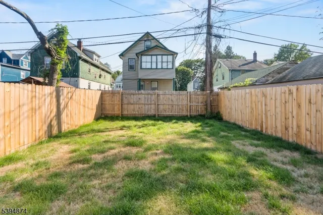 a view of a house with a yard and wooden fence