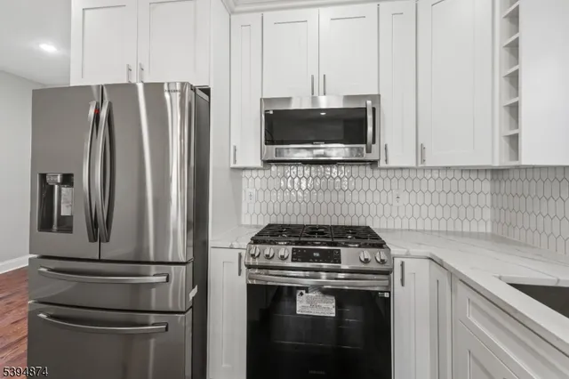 a kitchen with appliances a refrigerator and cabinets
