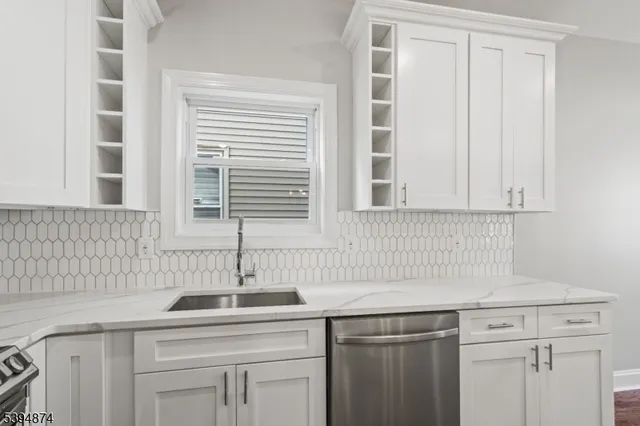 a kitchen with stainless steel appliances granite countertop a sink and a window