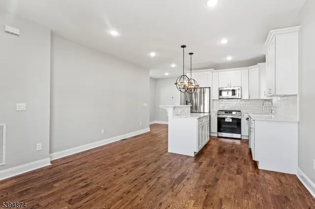 a kitchen with a refrigerator and a wooden floor