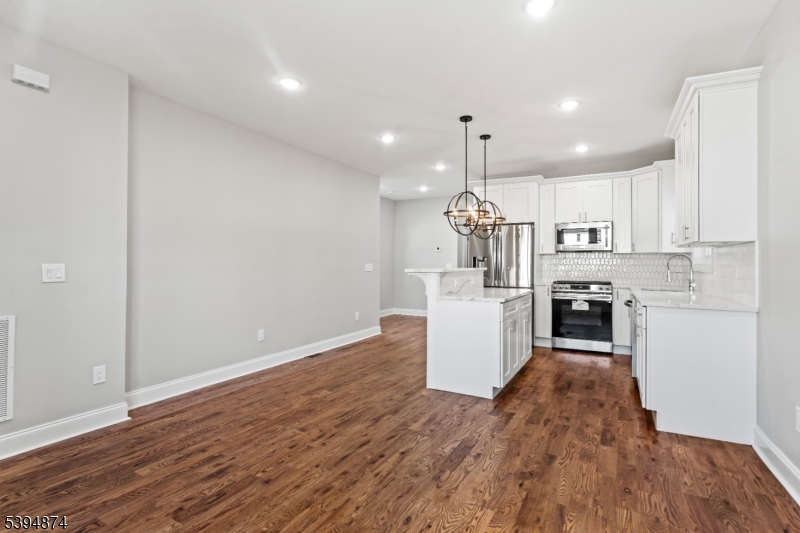 53 Marcy Avenue, Unit 1 East Orange, NJ 07017 - Photo 6 of 23 a kitchen with a refrigerator and a wooden floor