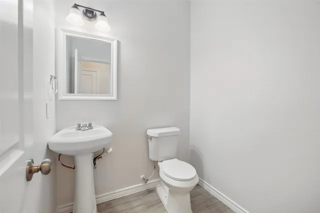 a bathroom with a sink toilet and a mirror