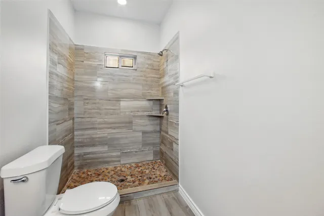 a bathroom with a toilet and a shower