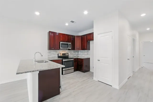 a kitchen with stainless steel appliances granite countertop a sink stove and refrigerator