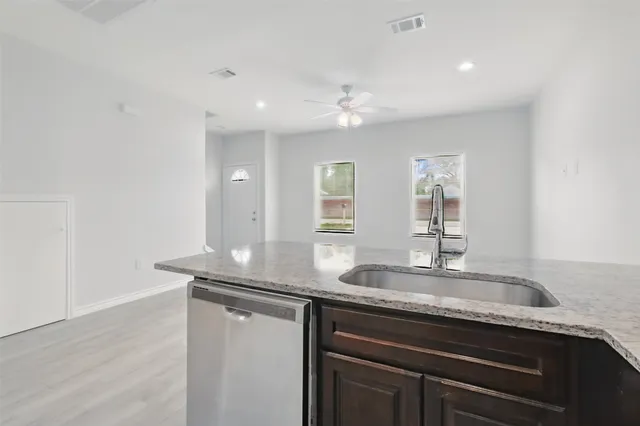 a kitchen with granite countertop cabinets stainless steel appliances and a sink